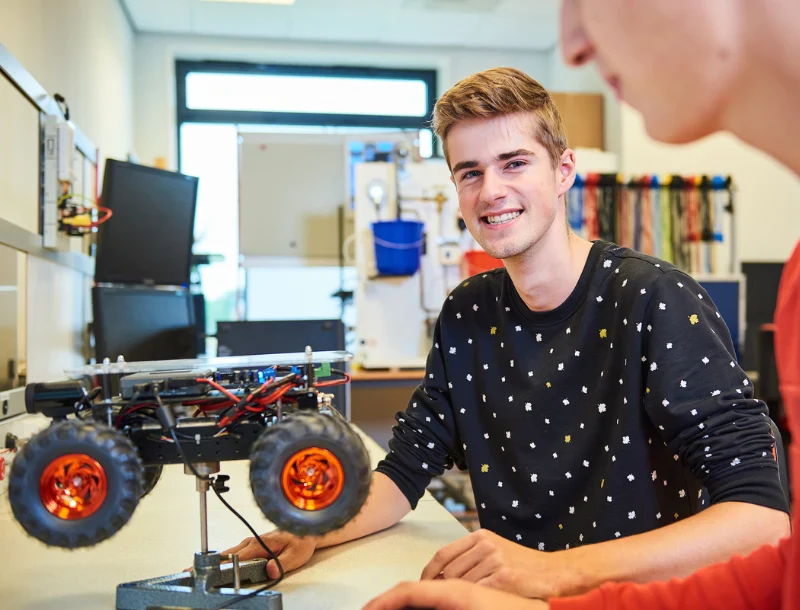 Studenten met een robot auto in de klas agrotechniek en engineering